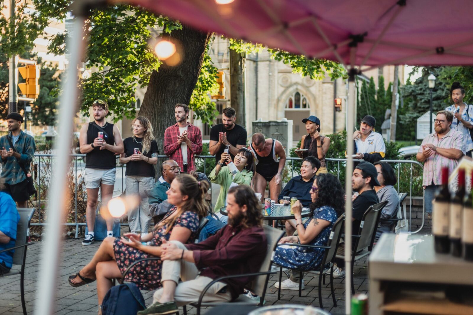 Photo of audiences at the SummerWorks party, sitting in the Factory Theatre courtyard.